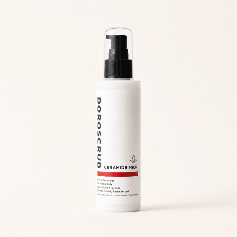 CERAMIDE MILKのセラミド配合保湿美容液。白いボトルが木の台に置かれたDOROSCRUBの商品イメージ。